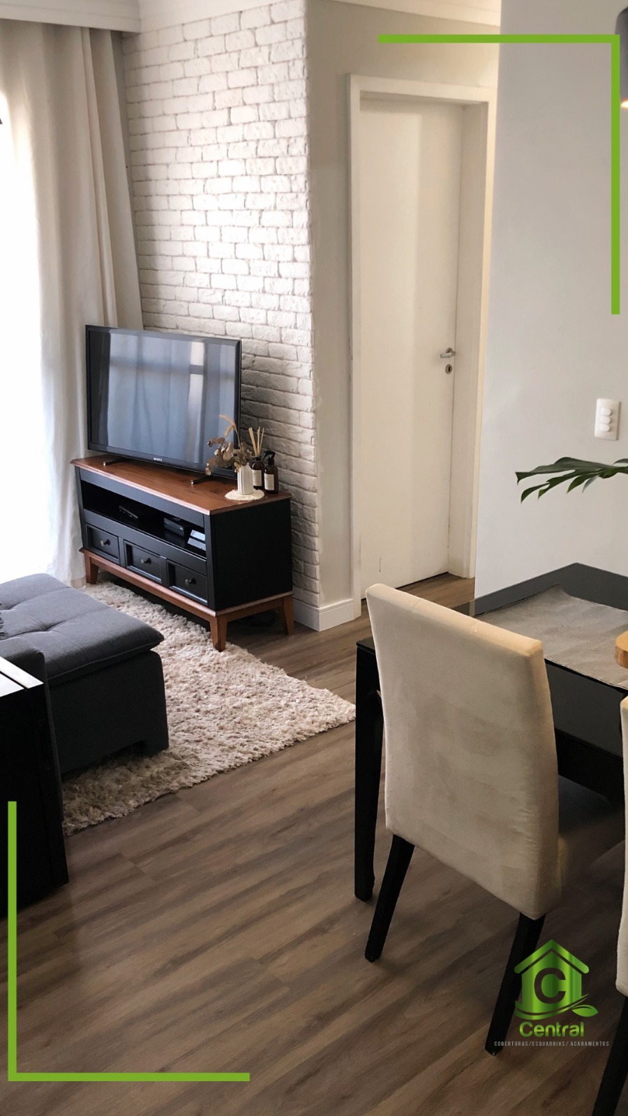 Sala de TV em tom escuro com piso vinílico